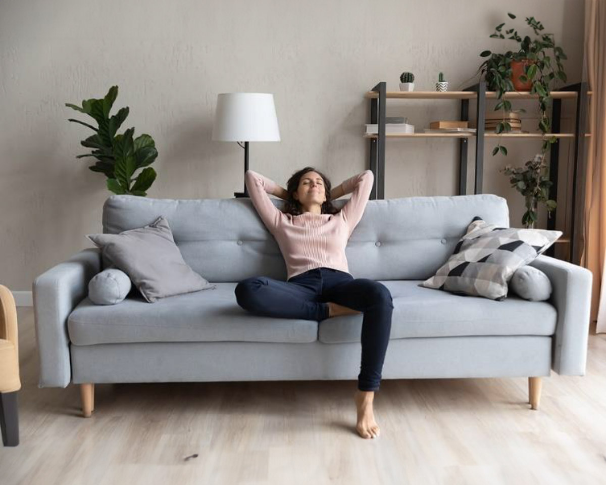 ront full length view tranquil millennial pretty woman relaxing on comfortable sofa in living room. Peaceful young lady sleeping, reducing stress, enjoying lazy weekend time on sofa alone at home.